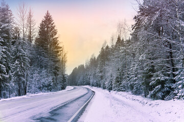 Obraz premium Snowy road in winter forest. Beautiful frosty white landscape at dawn.
