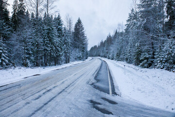 Obraz premium Snowy road in winter forest. Beautiful frosty white landscape.