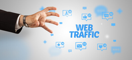 Close-Up of cropped hand pointing at WEB TRAFFIC inscription, social networking concept