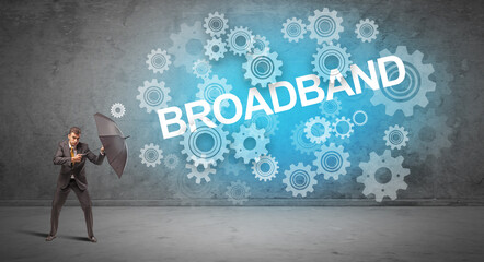 Businessman defending with umbrella from BROADBAND inscription, technology concept