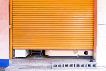 A closeup shot of automatic metal roller door used in factory, storage, garage, and industrial warehouse. The corrugated and foldable metal sheet offer space saving and provide urban and rustic feel