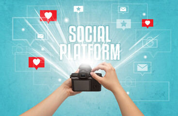 Close-up of a hand taking photos with SOCIAL PLATFORM inscription, social media concept