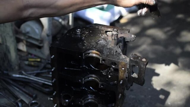 Car engine repair technician hand cleaning engine block assembly