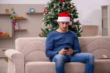 Young man celebrating Christmas alone at home
