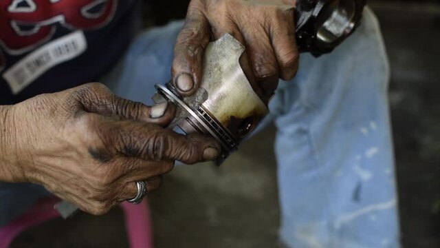 Car engine repair technician removing piston ring