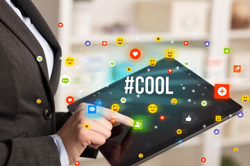 Close up of business person playing multimedia with social media icons and #COOL inscription