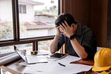 Asian male architect are feeling sick and tired or exhausted from office work.