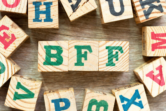 Alphabet letter block in word BFF (Abbreviation of best friend forever) with another on wood background