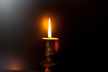 A burning candle in a candle stand