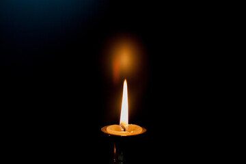 A burning candle in a candle stand