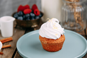 Chocolate dessert with soft milk cream. Tartlet with buttercream on a wooden background.