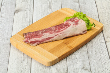 Raw beef bacon over wooden board