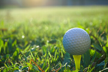 Golf ball on tee in beautiful golf course at sunset background
