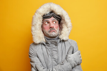 Arctic challenge. Frozen man trembles during extreme freeze during winter looks above wears warm...