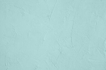 The surface of the plaster is a trendy color of tidewater green. Horizontal orientation, selective focus.