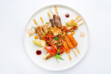 meat and fish kebabs on white plate