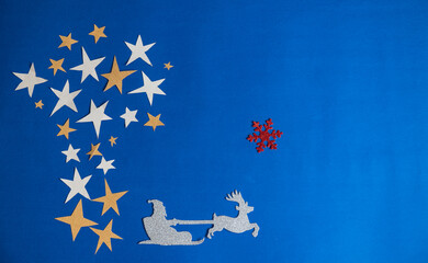 Christmas decoration, Christmas tree made with star and Santa riding on deer sled in blue background.