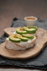 Avocado sandwiches with espresso for breakfast on walnut wood table
