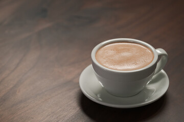 Cup of hot cocoa drink on walnut wood table