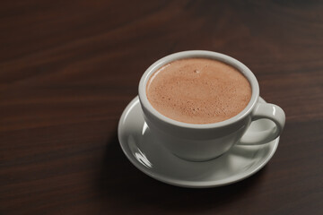 Cup of hot cocoa drink on walnut wood table