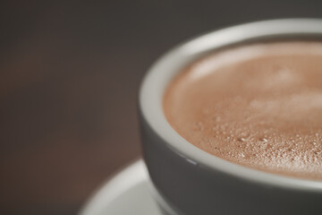 closeup of hot cocoa drink on walnut wood table