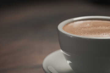 closeup of hot cocoa drink on walnut wood table
