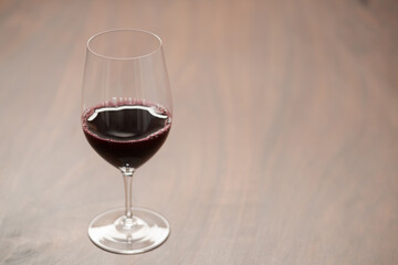 Red wine in wineglass on black walnut table with copy space