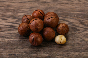 Brown macadamia nut heap over background