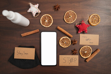 flat lay with smarthone and christmas decorations on walnut table