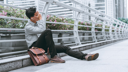 Failed business people sitting dejectedly on the pedestrian bridge