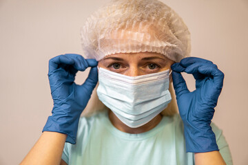 paramedic in a mask from coronavirus takes off the mask
