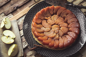 tarte tatin entière dans un plat moderne sur table en bois