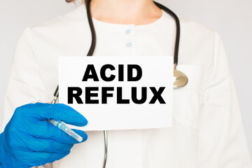 The doctor's blue - gloved hands show the word ACID REFLUX - . a gloved hand on a white background. Medical concept. the medicine