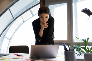 Pensive young mixed race lady corporate employee project developer data analyst working with...