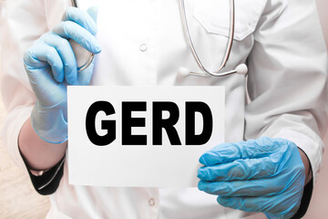 The doctor's blue - gloved hands show the word GERD - . a gloved hand on a white background. Medical concept. the medicine