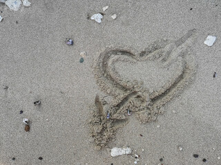 Fototapeta na wymiar heart with arrow in fine sandy beach on vacation