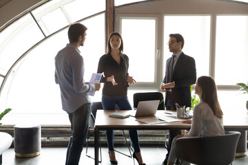 Concentrated millennial multiethnic colleagues teammates brainstorming sharing skills ideas planning sales strategy discussing solution of problem on briefing meeting seminar at office conference room