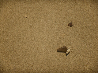 Fototapeta na wymiar smoothe fine sand with stones in the sun
