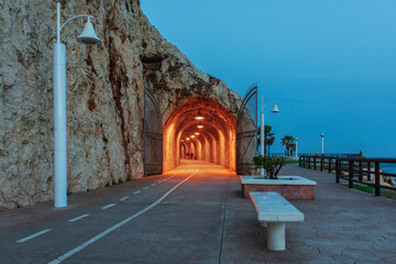 Paseo de los Tuneles del Cantal in the Rincon de la Victoria, Malaga, with the interior of the tunnel illuminated.