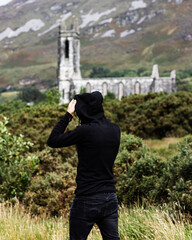 Person with a black jumper looking at an old chruch in Dunlewey, Donegal, Ireland