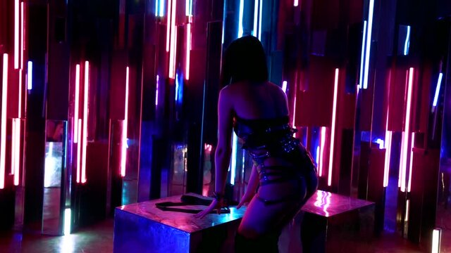 erotic dance of young sexy woman in strip club, leather underwear and high heels boots