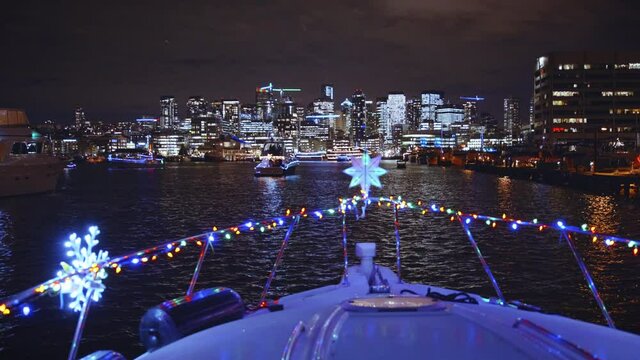 Holiday Lights on Front of Boat with Illuminated City Skyline Buildings
