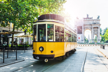 Fototapeta na wymiar Arch of Peace (Arco della Pace) view with nostalgic yellow tram in Milano, Italy.
