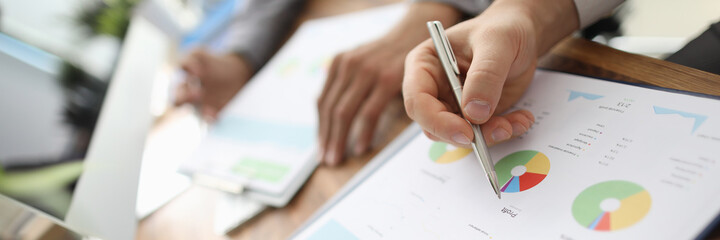 Young project managers sitting at their places and working together at new scheme of future development