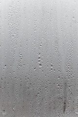 Natural drops of water flow down the glass, high humidity in the room, condensation on the glass...