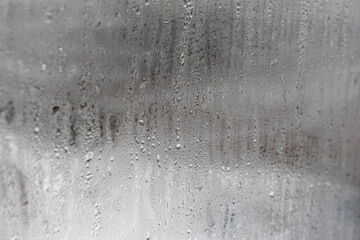 Close up for misted glass with droplets of water draining down. Dripping Condensation, Water Drops Background Rain drop Condensation Texture
