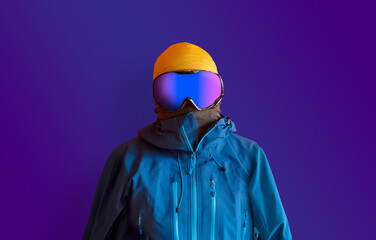 Snowboarder in full outerwear isolated over a dark purple background. 