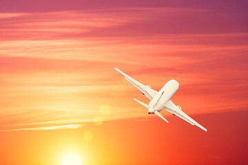 Plane is taking off at sunset bright sky.