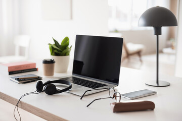 Workplace, laptop computer, coffee, smartphone, eyeglasses and headset at office desk. Business,...