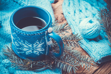 Obraz na płótnie Canvas handmade cup of tea,blue sweater, warm knitted hat, Christmas tree and New Year's decor, on an old wooden background